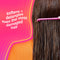 Person with long hair using a pink comb against a pink background with text about hair care.